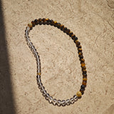This is a necklace with tiger's eye, clear quartz, gold-plated spacer and elastic cord.