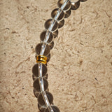 This is a necklace with tiger's eye, clear quartz, gold-plated spacer and elastic cord.