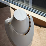 This is a necklace with tiger's eye, clear quartz, gold-plated spacer and elastic cord.