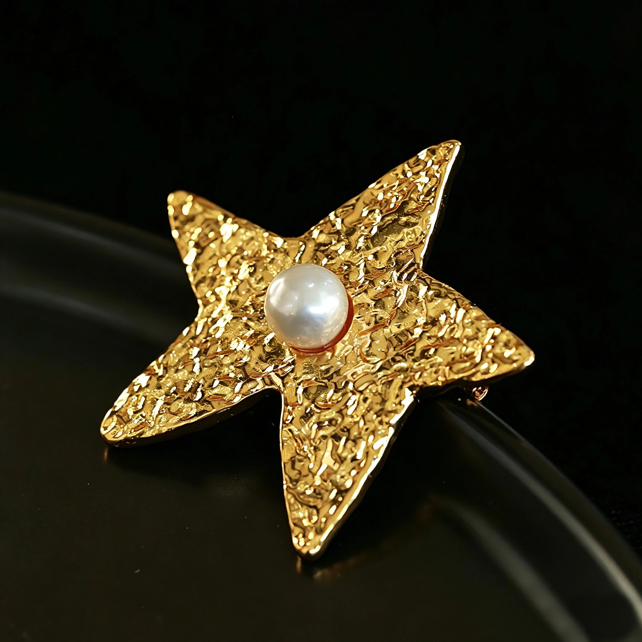 These vintage-style brooches come in star and Saturn-inspired planet shapes, with a hammered, textured finish in gold or silver tone. Each design is accented with a central gemstone, including pearl, red agate, or black onyx, adding a touch of celestial charm to any outfit.