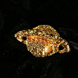 These vintage-style brooches come in star and Saturn-inspired planet shapes, with a hammered, textured finish in gold or silver tone. Each design is accented with a central gemstone, including pearl, red agate, or black onyx, adding a touch of celestial charm to any outfit.