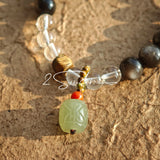 This bracelet combines genuine Silver Obsidian (look for the subtle silver sheen under light), high-clarity White Quartz, and Real Agarwood. Unlike synthetic imitations, our Agarwood carries a faint, natural woody scent that deepens over time. Plus, there is an Agate ring in the bracelet, which adds a touch of classical beauty. It feels grounded and real on your skin.