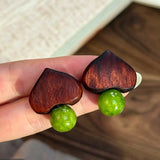 Crafted with dark wood heart‑shaped pieces paired with vivid green grape‑tone stone beads. This stud earring blends retro natural texture and fresh color contrast. It delivers a unique boho‑charm look for daily wear.