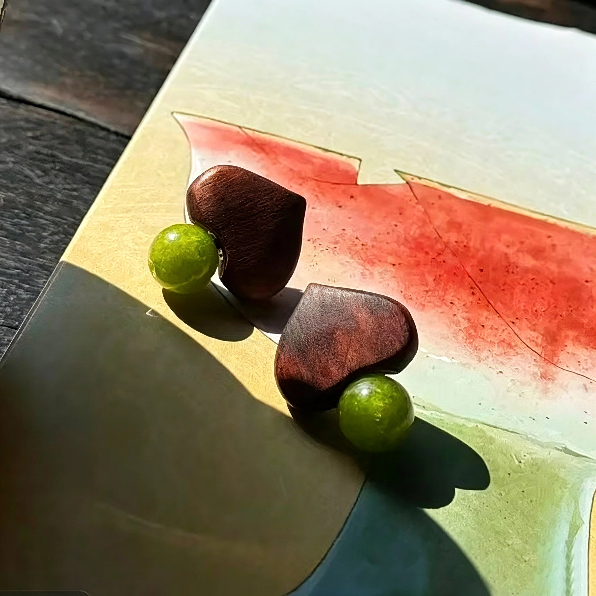 Crafted with dark wood heart‑shaped pieces paired with vivid green grape‑tone stone beads. This stud earring blends retro natural texture and fresh color contrast. It delivers a unique boho‑charm look for daily wear.