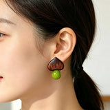 Crafted with dark wood heart‑shaped pieces paired with vivid green grape‑tone stone beads. This stud earring blends retro natural texture and fresh color contrast. It delivers a unique boho‑charm look for daily wear.