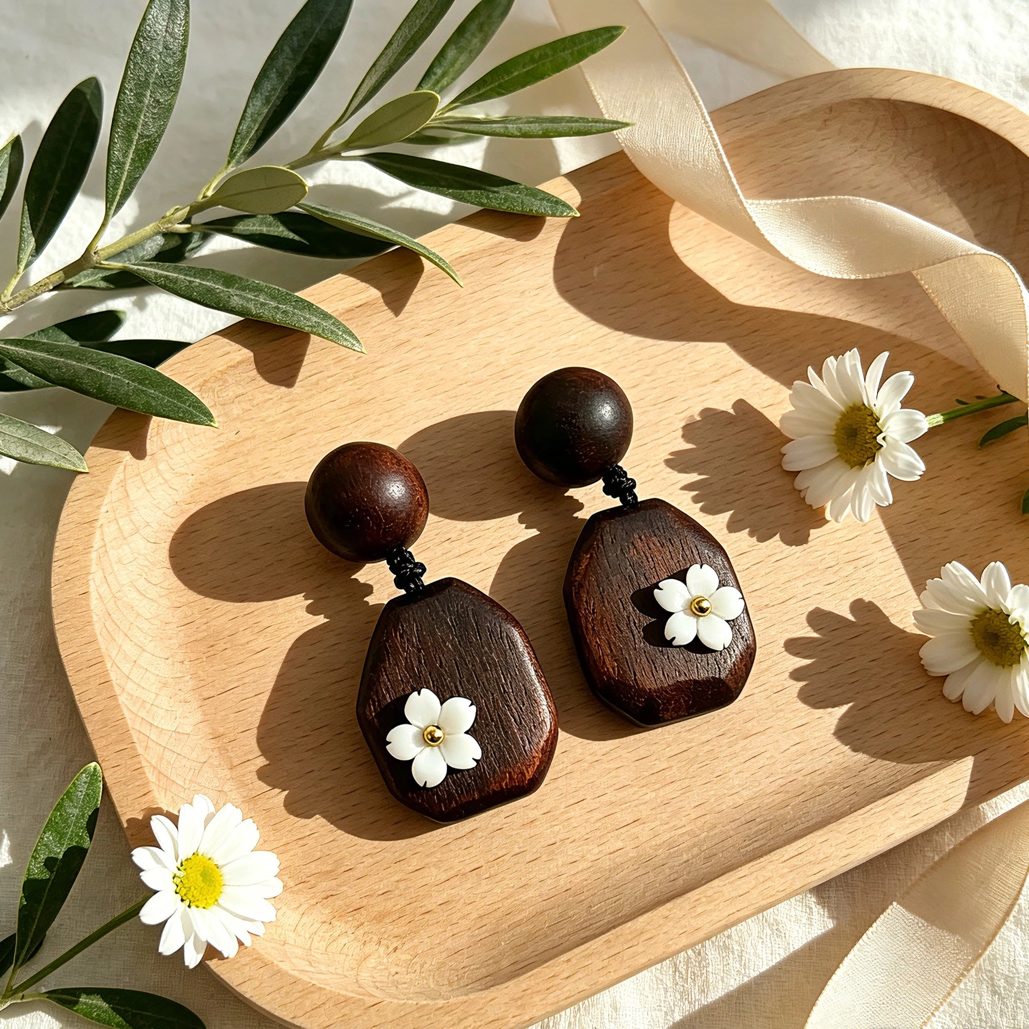 Crafted from vintage‑style dark wood, these drop earrings feature delicate small white flower accents with golden centers. Natural wood grain brings warm retro texture, suspended by black knotted cord for a soft boho‑charm look. They are lightweight statement pieces perfect for daily and casual styling.