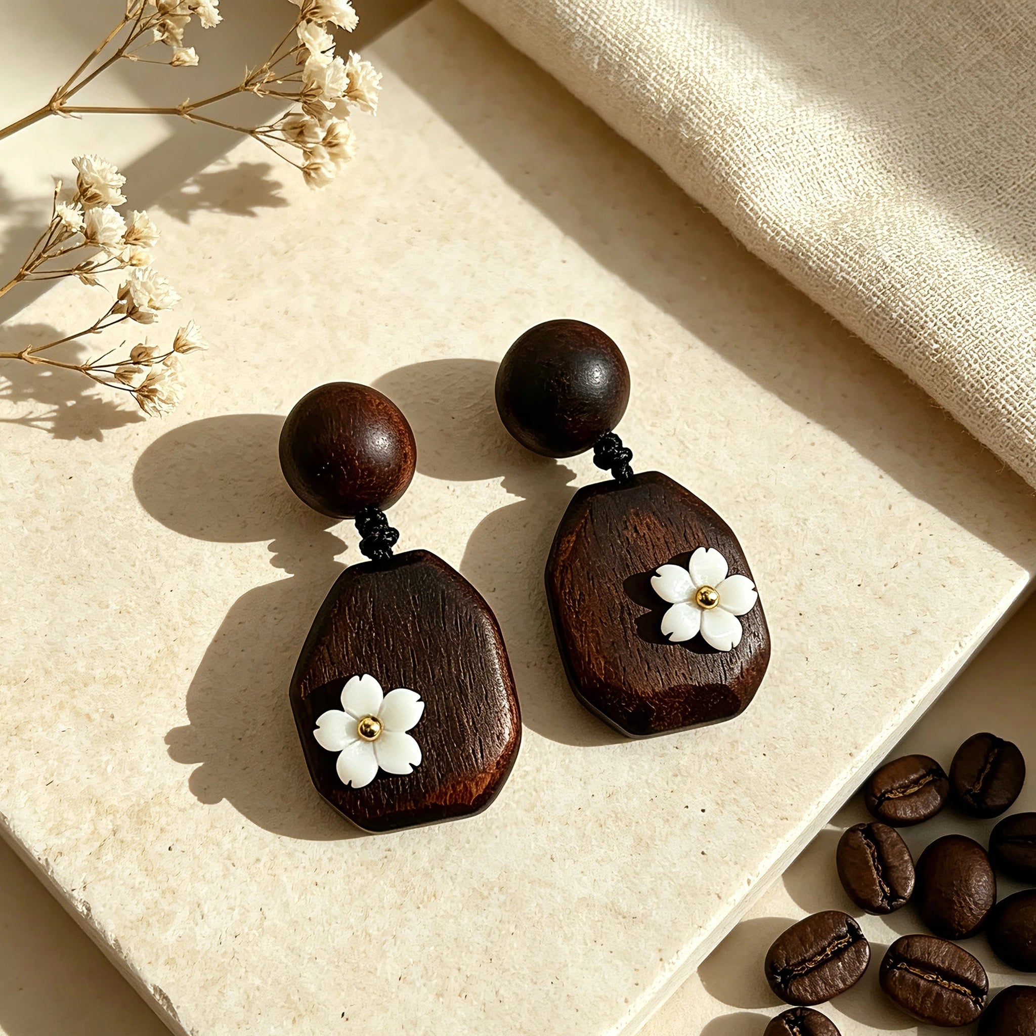 Crafted from vintage‑style dark wood, these drop earrings feature delicate small white flower accents with golden centers. Natural wood grain brings warm retro texture, suspended by black knotted cord for a soft boho‑charm look. They are lightweight statement pieces perfect for daily and casual styling.