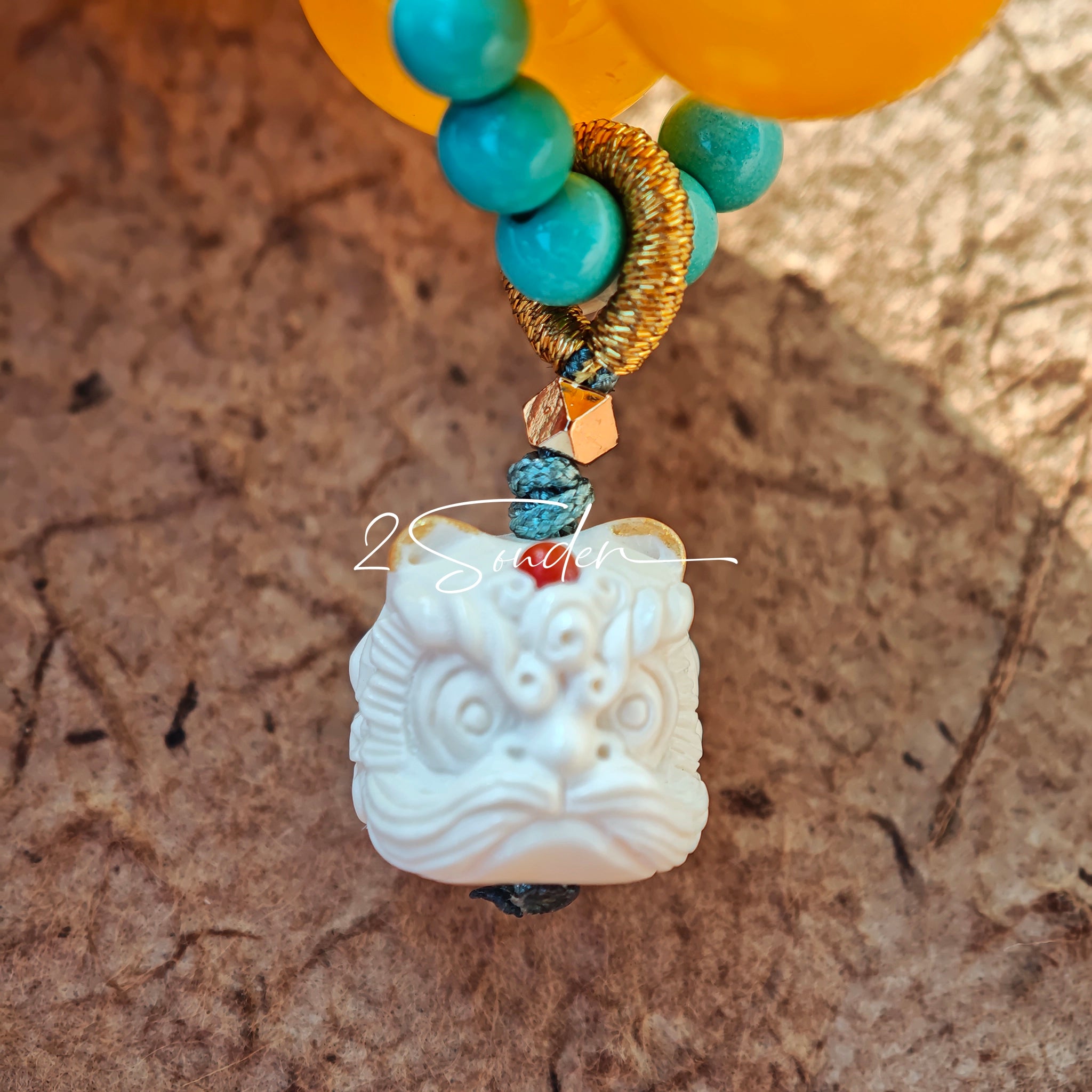This handcrafted bracelet features glossy 14mm yellow agate beads paired with one white agate bead. It is accented with turquoise beads and finished with a detailed mammoth ivory guardian lion charm, bringing a warm vintage ethnic vibe.