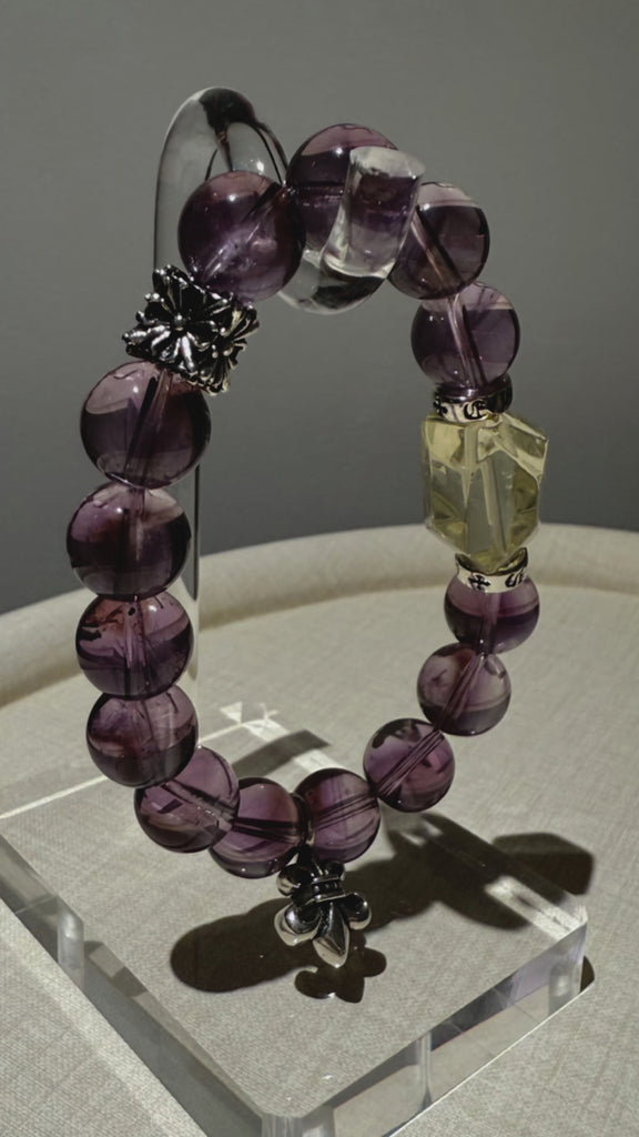 Twilight poetry for your arm—14 velvety amethyst orbs circle a wild sun-kissed citrine, flecked with sterling stardust in a hand-strung love letter.