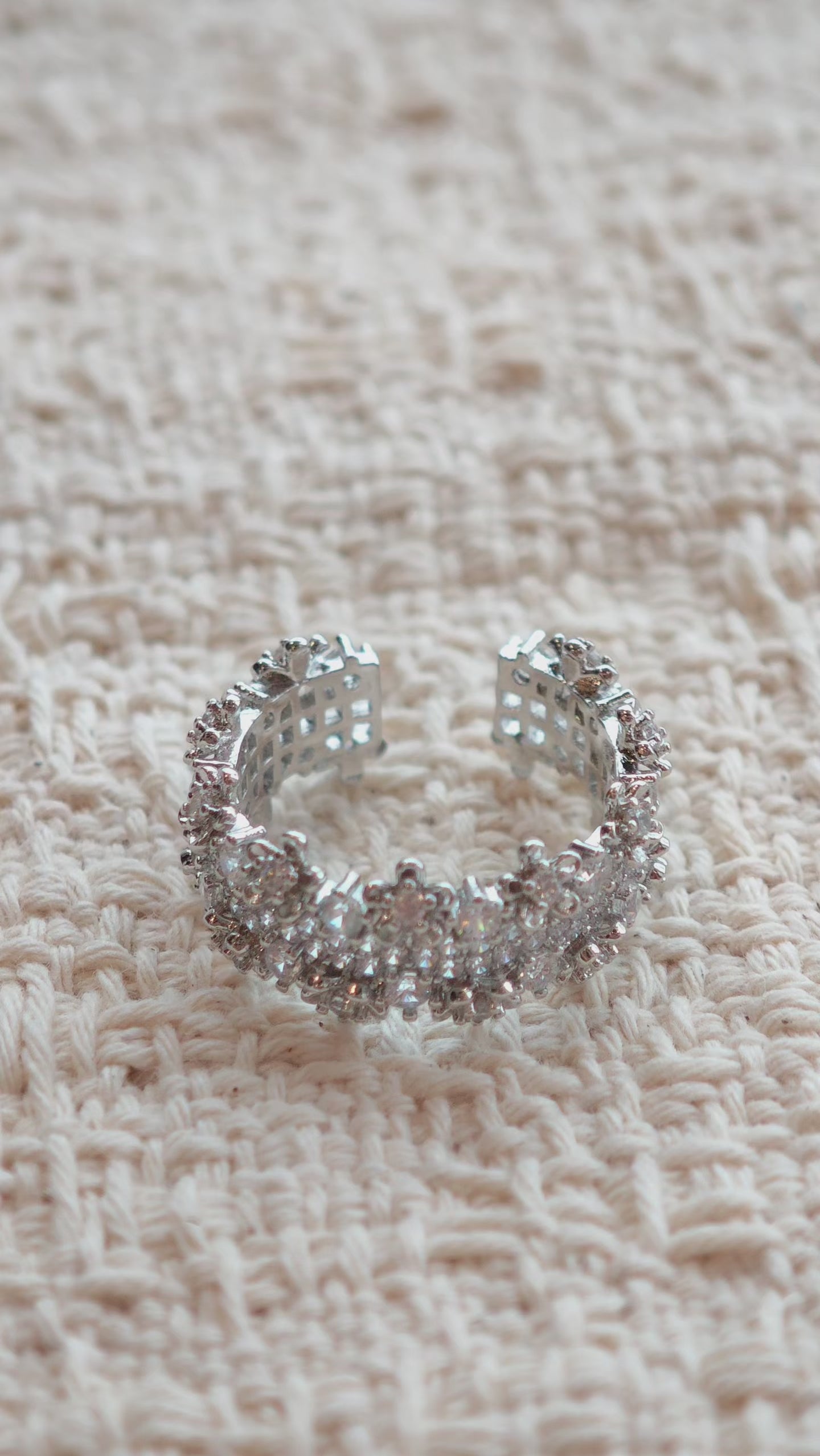 This snowflake zircon open ring features an intricate and textured band, adorned with clusters of sparkling zircon stones that mimic delicate snowflakes. Its adjustable open design ensures a comfortable fit, while the polished copper alloy metal reflects light beautifully, creating an elegant, frosty aesthetic. The detailed craftsmanship gives it a luxurious, eye-catching appearance ideal for adding a wintry charm to any look.