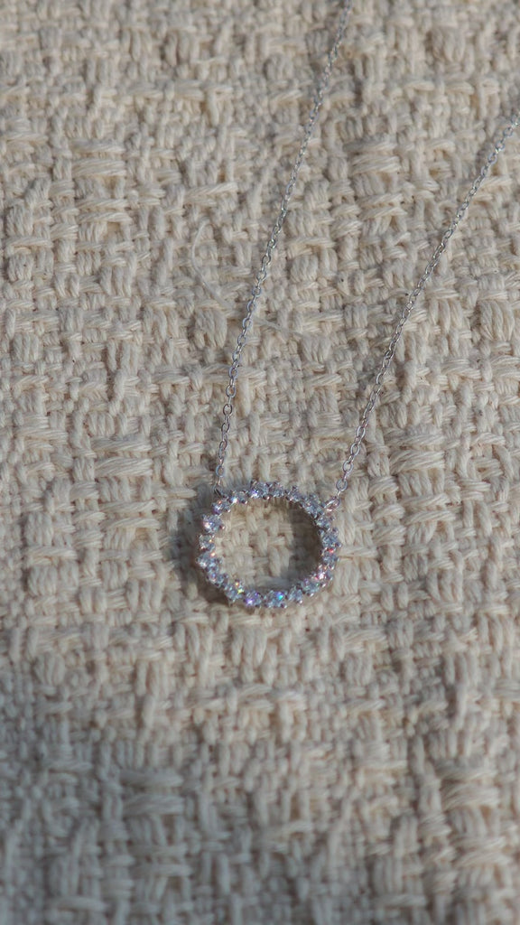 This S925 silver necklace features a delicate circular pendant encrusted with shimmering moissanite stones, forming an elegant open-circle silhouette. The slender silver chain complements the pendant perfectly, lending a refined and timeless charm to the piece. Its minimalist yet sparkling design makes it a versatile accessory for various occasions.