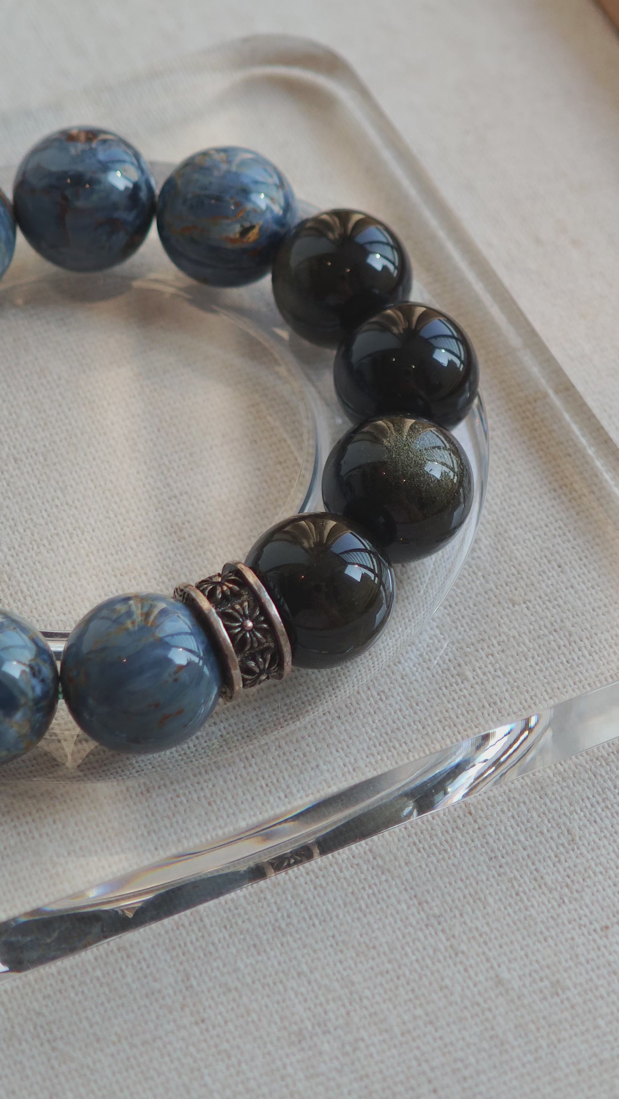 This is a bracelet consists of Blue Denim Pietersite and Golden Sheen Obsidian. The color of the bracelet is denim blue and black, accented by sleek silver spacer.