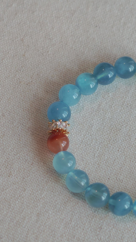 This is a gemstone bracelet that consists of 19pcs of 7-8mm aquamarine beads and 1pcs of red rutilated quartz. There are also 2 silver spacer beads in the bracelet. The main color of the bracelet is sky blue. The entire bracelet is translucent and beautiful.